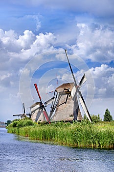 Ancient wind mills near a blue canal on a beautiful summer day at Kinderdijk, Holland