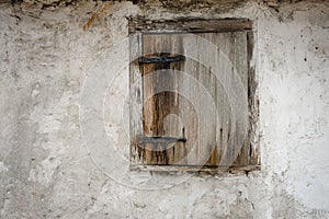 Ancient wood window shutter and black iron hinges