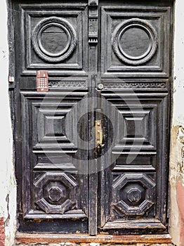 ancient wooden black doors with infill and door handle