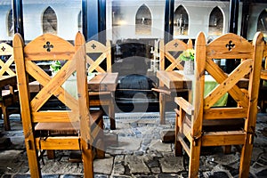 Ancient wooden chairs with medieval decorations in vintage restaurant with many feudal ages decor elements