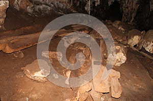 Ancient wooden coffins from prehistoric burial site inside Tham Lod Cave, Mae Hong Son, showing weathered teakwood remains amid photo