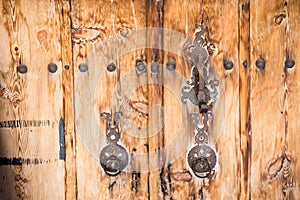 Ancient wooden door with door knocker rings