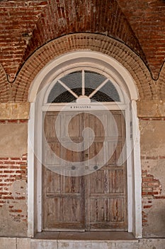 Ancient wooden door with lock in old stone wall