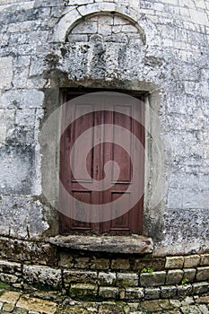 Ancient wooden door in stone castle wall.