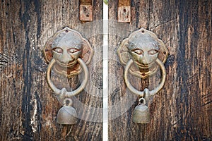 Ancient wooden gate two door knocker rings.