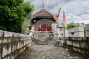 Ancient wooden gatehouse of stone fort in cloudy spring after ra