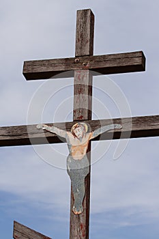 ancient, wooden, Orthodox cross with a crucifix against the sky.