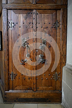 Ancient wooden sacristy door with skull and snake on door mounting, Saint Michael Church Schwabisch Hall, Germany