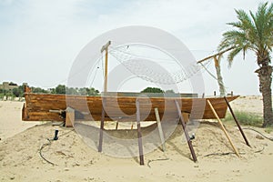 Ancient wooden small ship on the sand in the desert