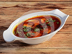 Anda Masala or Egg Curry is popular indian spicy food, served in a ceramic bowl over rustic wooden background. Selective focus photo