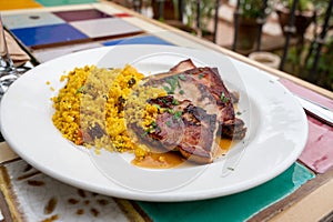 Andalusian cuisine, spicy cous-cous with grilled pork ham filet