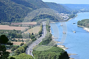 Andernach, Germany - 08 27 2020: Rhine with ship traffic and main road B9 with a few trucks