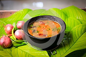 south indian famous rasam,sambar served in a traditional mud pot closeup with selective focus and bl photo