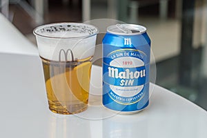 Mahou beer in a plastic cup with McDonald logo and can of Mahou sin beer