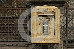 Andorra - santa coloma - the old yellow french post box set against a de-focused old green fence background photo