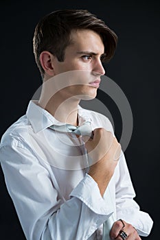 Androgynous man adjusting his tie