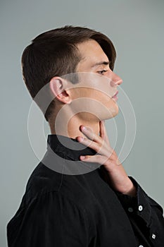 Androgynous man touching his neck