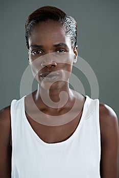 Androgynous man in white waist posing against grey background