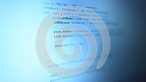 Android mobile development. Application source code on notebook blue screen background.