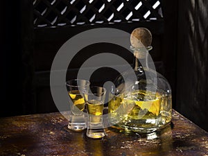 anejo and glasses on color background