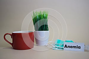 Anemia text, grass pot, coffee cup, syringe, and face green mas. Healtcare/Medical and Business concept