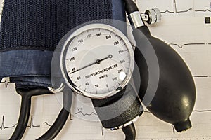 Aneroid sphygmomanometer with dial, bulb, air valve and a folded cuff, just after use to measure blood pressure in a patient with photo