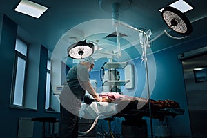 An anesthetist prepares a patient for surgery. Team of surgeons at work in the operating room.