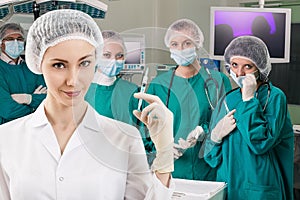 Anesthetist with syringe and surgery teem