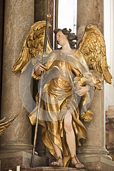Angel, beautiful angel statue with golden wings and dragon in St. Peters Church, Munich