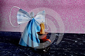 Angel from blue face protection mask burning candle and christmas decoration background