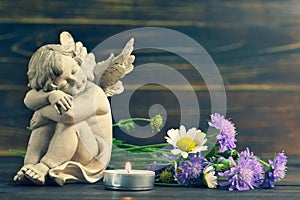 Angel, candle and wildflowers