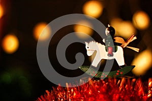Angel Christmas ornament ridding a horse with green garland