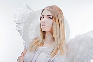 An angel from heaven. Young, wonderful blonde girl in the image of an angel with white wings.