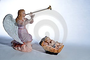 Angel playing Herald trumpet over baby Jesus