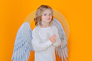 Angel prayer kids. Kid wearing angel costume white dress and feather wings. Innocent child.