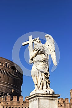 Angel statue with a cross, Castel Sant`Angelo, Rome, Italy. Blue sky