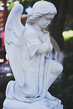 Angel vintage sculpture. Stone sculpture in the shape of an angel. Sculpture of an angel bowed his head at the entrance.