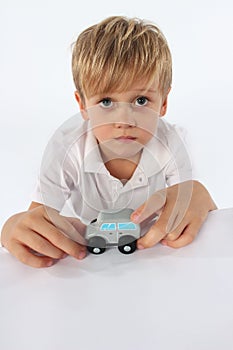 An angelic looking child boy showing his favorite simple wooden car toy