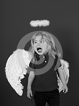 Angels also cry. little angel boy crying with white feather wings and halo