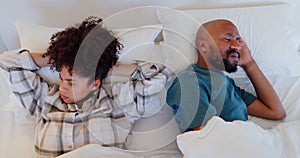 Anger, argue and ignore with a black couple in bed after a disagreement or fight from above. Divorce, breakup or