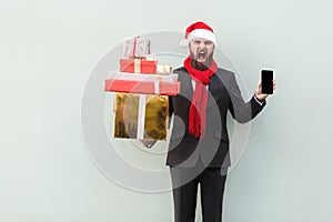 Anger businessman holding on hands gift box and phone. Looking a
