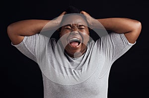 Anger, frustrated and black woman screaming, depression and mental health on a dark black studio background. Person