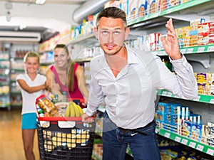 Anger male customer with family and purchases in shopping cart