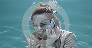 ANGER MANAGEMENT Cinematic underwater portrait of young angry redhead business woman shout on phone call slow motion.