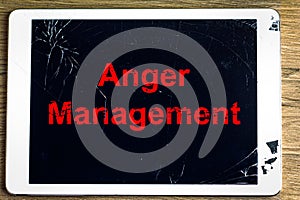 Anger Management message on a smashed and cracked tablet screen, anger management and frustrating technology concept