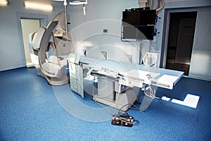 Angiographer in a modern hospital for heart surgery with a remote and monitors