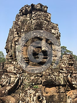 Angkor Wat in Siem Reap, Cambodia. Stone faces carved in the ancient ruins of Bayon Khmer Temple