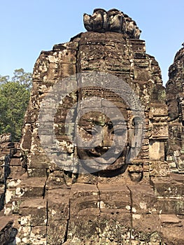 Angkor Wat in Siem Reap, Cambodia. Stone faces carved in the ancient ruins of Bayon Khmer Temple