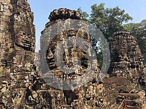 Angkor Wat in Siem Reap, Cambodia. Stone faces carved in the ancient ruins of Bayon Khmer Temple