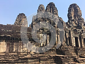 Angkor Wat in Siem Reap, Cambodia. Stone faces carved in the ancient ruins of Bayon Khmer Temple